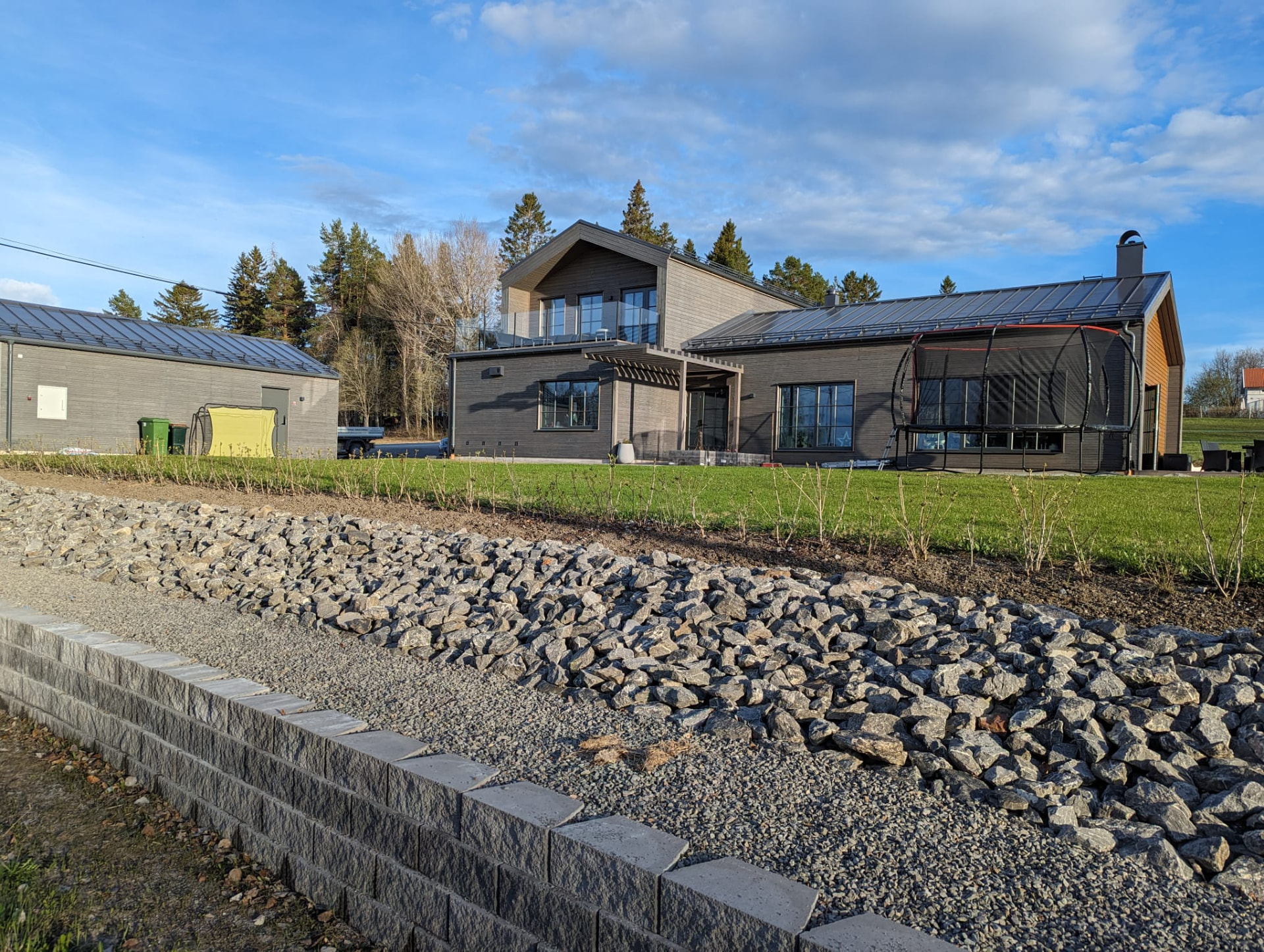 Dränerande stenbädd och stödmur framför villa